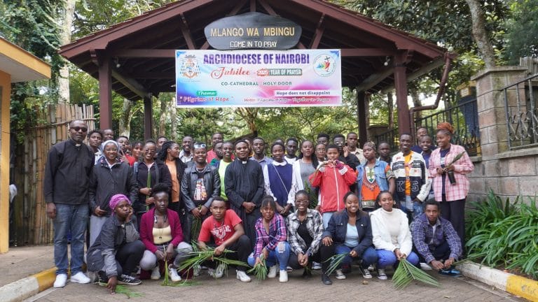 Fr. patrick, Fr. Faustin Saasita and Younib organization members pose for a photo at the Holydoor in resurrection garden